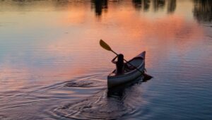 photo of person riding kayak during dawn